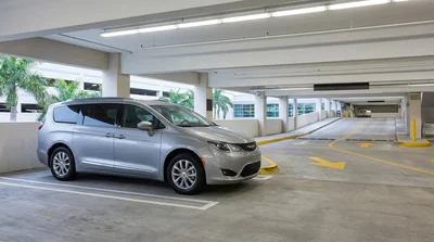 Rows of vehicles parked in car rental bays at Orlando Airport with overhead signs pointing to the exit lanes