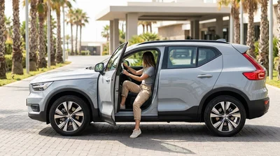 Side profile of a modern SUV car rental parked on a sunny palm-lined street in Miami