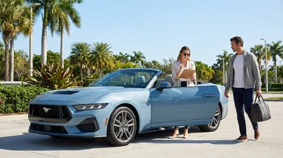White car rental driving on a sunny coastal highway lined with palm trees in Florida