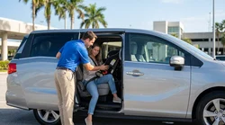 Staff member fitting a child seat in the backseat of a car rental in Florida