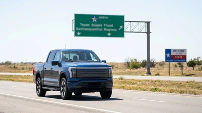 Red car rental driving on a long highway through a sunny Texas desert landscape
