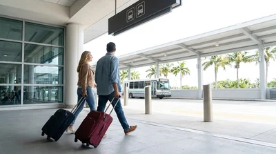 Passengers boarding a white car hire shuttle bus outside the Orlando airport terminal