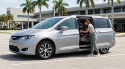 Child seat secured in the backseat of a car hire parked under palm trees in Miami