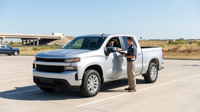 A white car rental driving down a long straight desert highway in Texas
