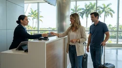 Person handing a credit card to an agent at a car hire desk in Miami