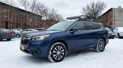 White AWD SUV car rental driving on a snow-covered street in New York