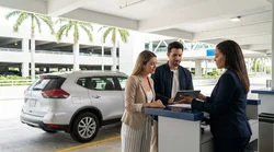 Customer handing a credit card to an agent at a car rental desk in Miami