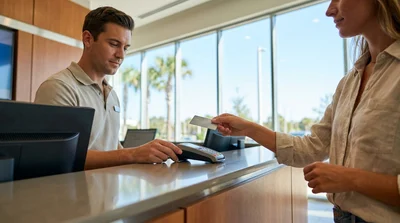 Person handing a credit card to an agent at an Orlando car rental desk