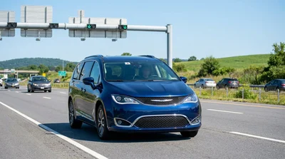 Silver car rental passing through an E-ZPass toll booth on a Pennsylvania highway