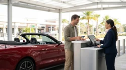 Customer handing a credit card to a service agent at a car rental counter in Orlando