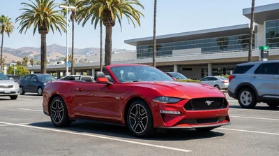 A modern car rental driving along a scenic coastal highway overlooking the ocean in sunny California