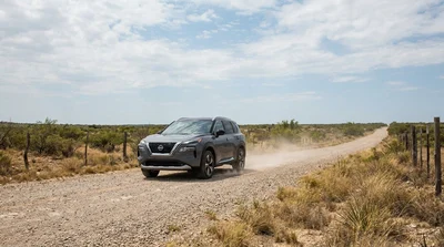 A white car rental driving along a dusty unpaved gravel road in Texas