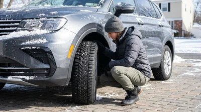 Black car rental with winter tyres parked on a snow-covered street in New York