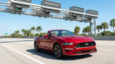 White car rental approaching an electronic toll plaza on a sunny Florida highway