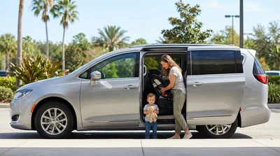 Child safety seat securely installed in the back of a car rental parked on a sunny Orlando street