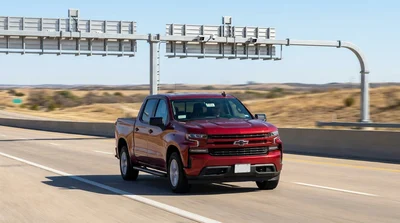 White car rental passing under an electronic toll gantry on a Texas highway
