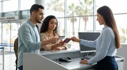 Person handing a photo ID to a staff member at a car rental counter in Miami