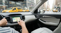 Dashboard sat nav screen displaying a map inside a car rental driving through busy New York streets