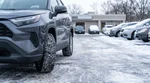 Car hire equipped with winter tires driving down a snowy street in New York