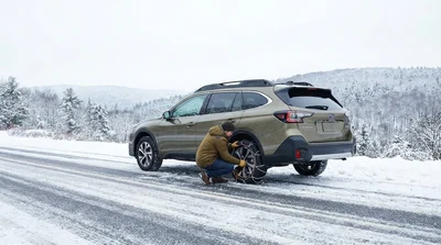 A car rental driving on a snow-covered road surrounded by winter trees in Pennsylvania