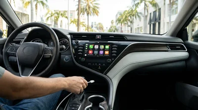 Dashboard screen showing Apple CarPlay and a USB charging cable inside a Los Angeles car rental