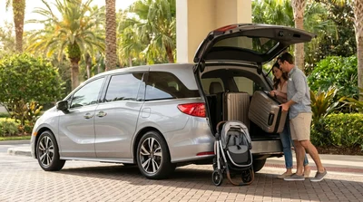 Two large suitcases and a pram loaded into the open trunk of an Orlando car rental