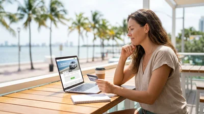Woman driving a car rental down a sunny palm tree lined street in Miami