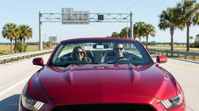 SunPass transponder on the dashboard of a car rental approaching an Orlando toll booth