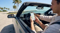 Driver looking at a smartphone map screen inside a car rental in Florida