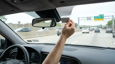 E-ZPass transponder mounted on the windshield of a car rental driving on a New York highway