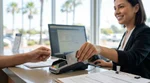 Close-up of hands passing a credit card across a car hire counter in California