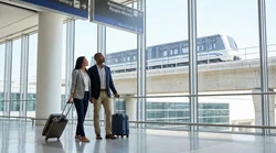 Travelers walking from the Newark AirTrain to a car hire shuttle bus in New York