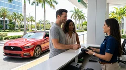 Person handing a credit card to an agent at a car hire counter in Miami