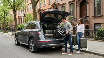 Family loading a pram and luggage into the trunk of an SUV car rental in New York