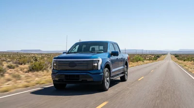 Silver car hire driving on a long dusty highway through the Texas desert under a clear blue sky