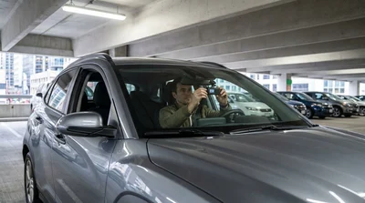 Driver mounting a dash cam on the windshield of a car rental in New York