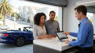 Customer handing a credit card to an agent at a car rental counter in San Francisco