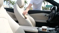 Close-up of a spilled coffee stain on the front fabric passenger seat of a Florida car rental