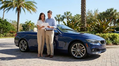 Driving a car rental down a scenic coastal highway lined with palm trees in Florida