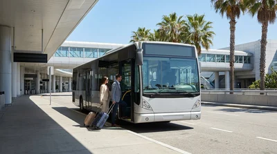 Travelers walking with luggage on a sidewalk at Los Angeles airport toward a car rental facility