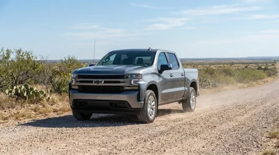 White car rental driving on an unpaved gravel road in rural Texas