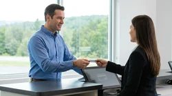 Person handing a credit card to an agent at a car rental desk in Pennsylvania