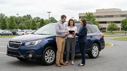 Two friends exchanging keys next to a car rental on a rural road in Pennsylvania