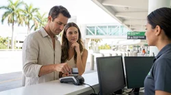 Person handing a credit card to an agent at a Florida car hire desk