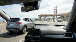 Red car rental driving past the suspension cables of the Golden Gate Bridge in San Francisco