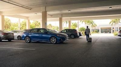 Rows of parked cars in a concrete parking garage near the car rental desks at Orlando Airport