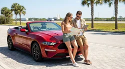 White car rental driving on a sunny coastal highway in Florida surrounded by palm trees