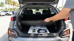 Open trunk of a silver sedan at a Florida car rental lot revealing a spare tyre