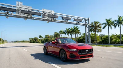White car rental passing under a cashless toll gantry on a sunny Florida highway