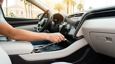 Hand plugging a phone charging cable into the dashboard USB port of a Las Vegas car rental